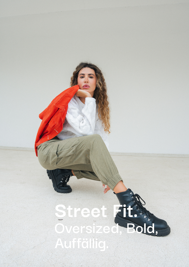 Auffälliger Street Fit Look bei sneekrs mit Cargo-Hose, roter Jacke und schwarzen Boots
